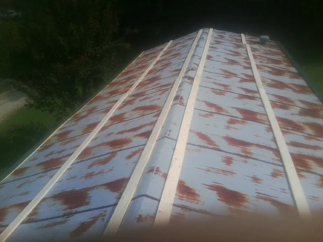 Rusted metal roof panels with new wood purlins before replacement — Storm Damage Roof Repair in Newtown by Roofing Brothers