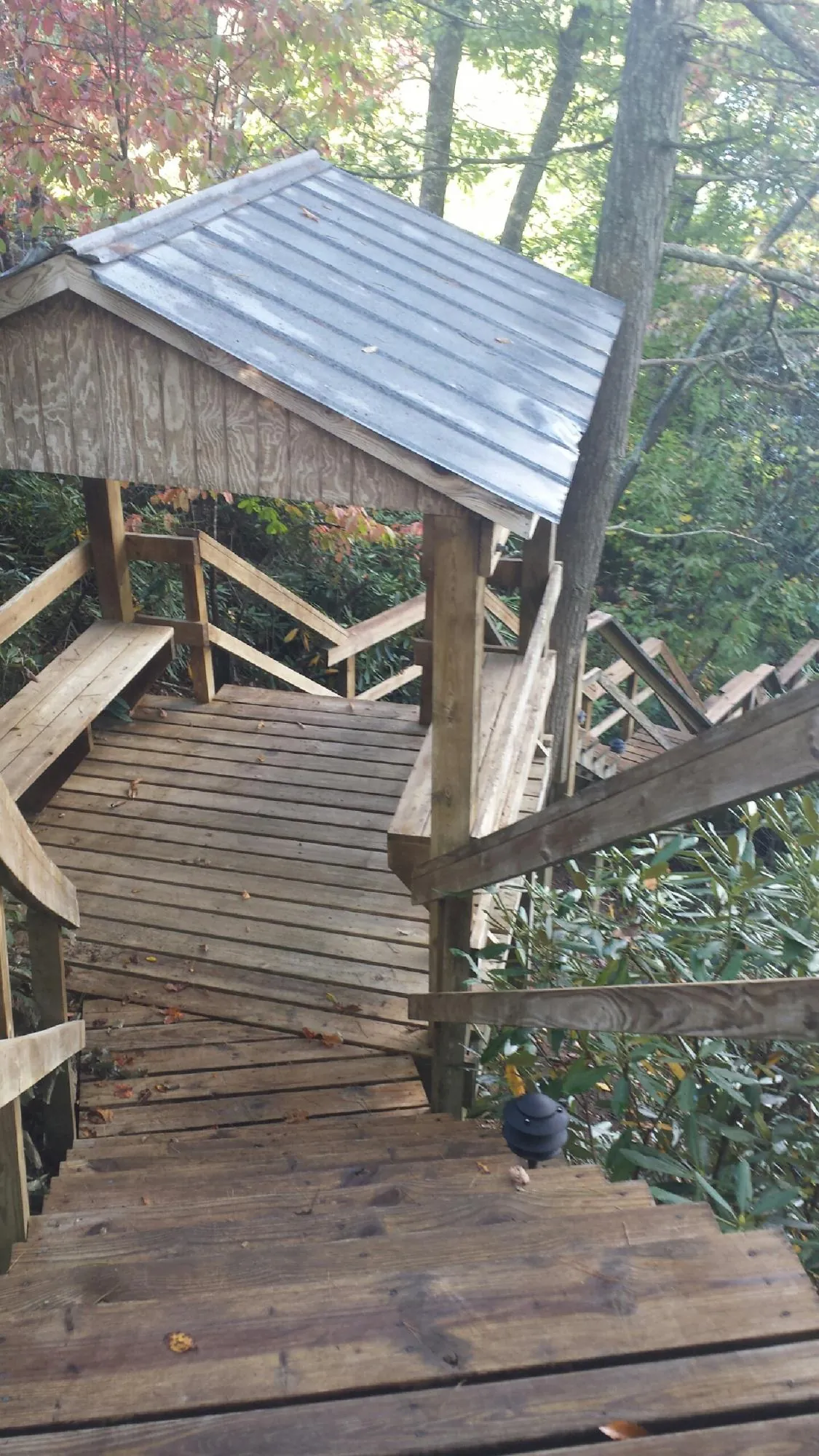 Metal roofed shelter over wooden steps on a wooded walkway — Skylight Repair & Installation work by our crew in Newtown